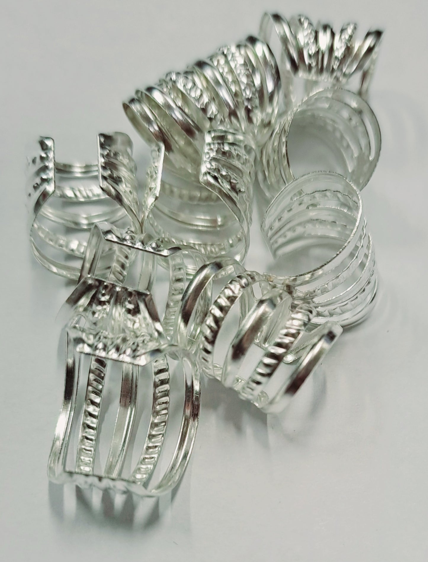 Anellini per treccine argento particolare con riga. 20 pz. Regolabili